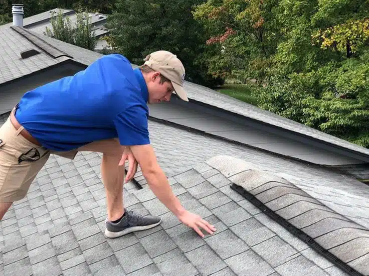 Certified specialist from a local roofing company conducting a free roof inspection to identify hail and wind damage in Peoria.