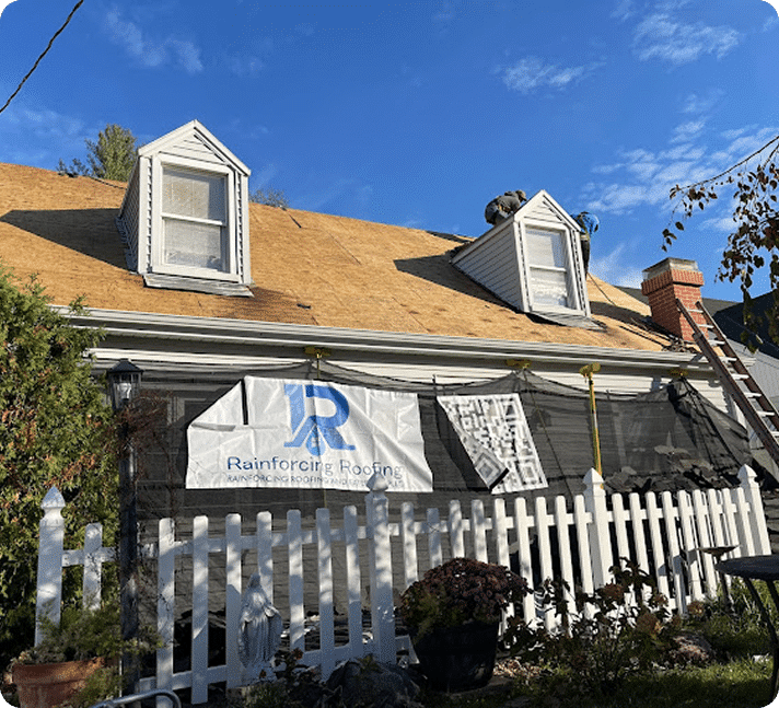 Professional roofing company job site in Central Illinois showing active roof restoration with a branded Rainforcing Roofing protective debris barrier