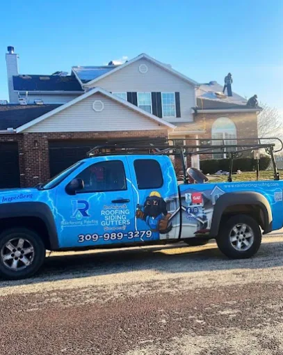 Rainforcing Roofing branded truck parked in a driveway while roofers install a new asphalt shingle roof in the background