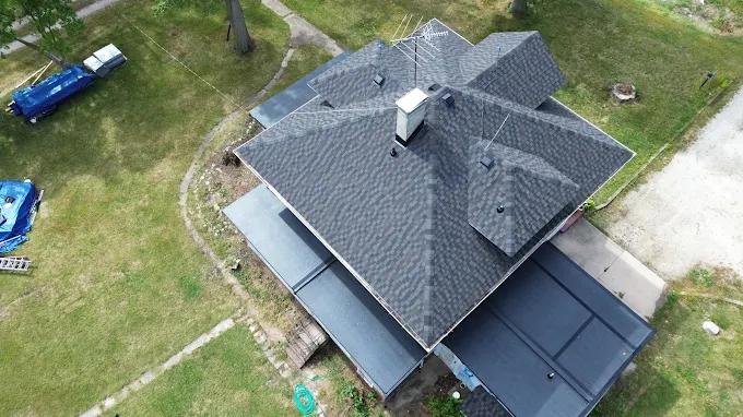 Aerial drone photo of a complex gray asphalt shingle roof with multiple hips and valleys on a Central Illinois home